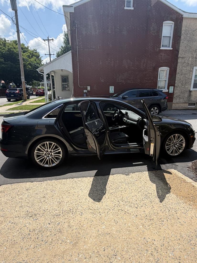 Audi A4 with all four doors open on a residential street