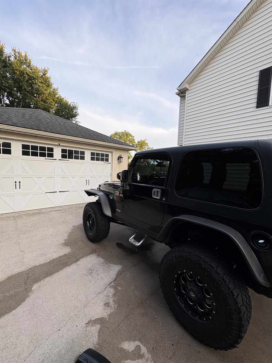 Black Jeep Wrangler finished in a residential driveway